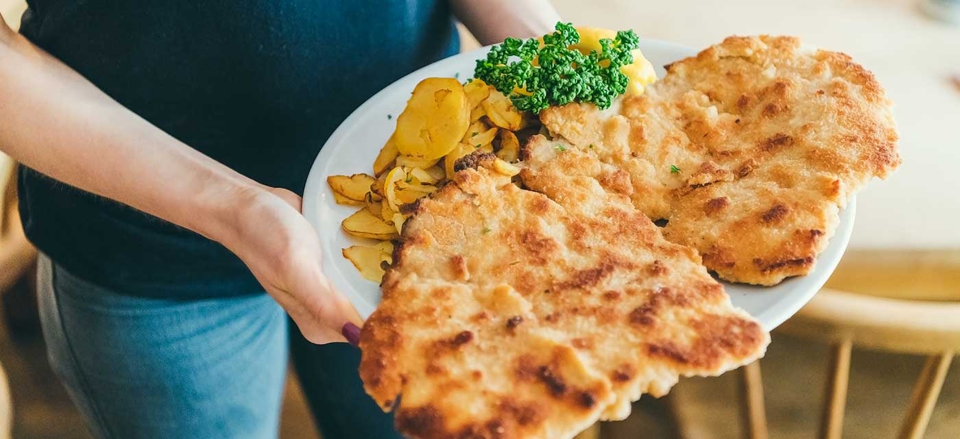 Een typische Oostenrijks gerecht; reuze Wiener Schnitzel met gebakken aardappelen