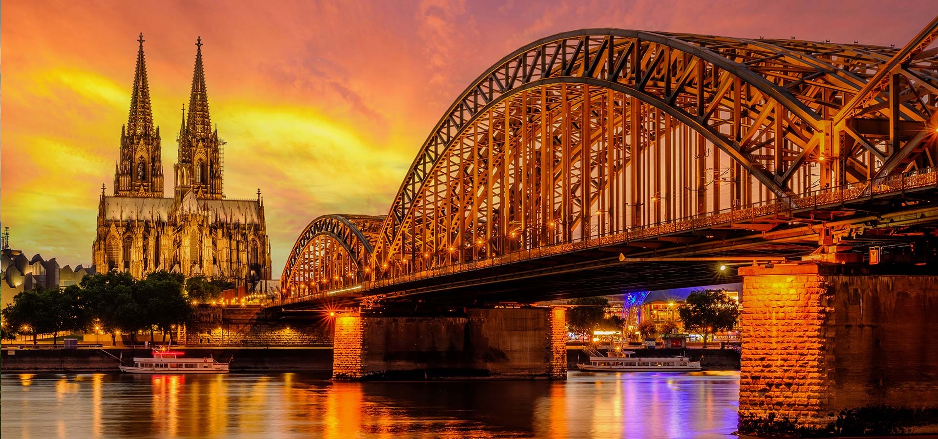 Nachtzicht op de Dom van Keulen en de rivier de Rijn onder de Hohenzollern-brug bij zonsondergang, de skyline van de stad Keulen 's nachts, regio Noordrijn-Westfalen, Duitsland